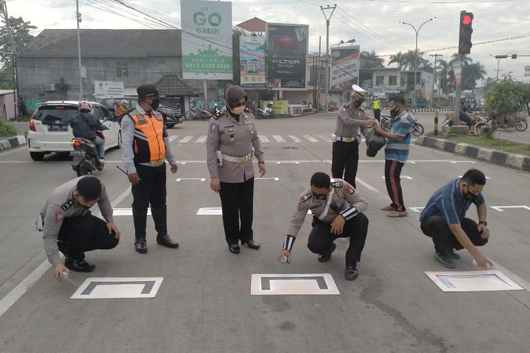 Petugas Ditlantas Polda Banten saat membuat markah jaga jarak di traffic light Cipocok, Kota Serang
