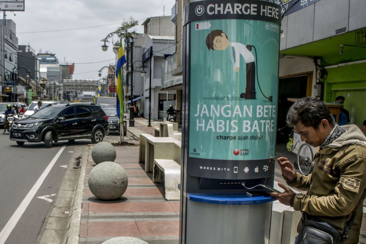 Warga mengisi daya telepon selular di fasilitas Charger Station di jalan Sudirman, Bandung, Jawa Barat, Kamis (12/10). Pemerintah Kota Bandung berencana menambah 100 fasilitas Charger Station di sejumlah tempat umum guna memudahkan masyarakat untuk mengisi daya telepon selular setiap saat. 