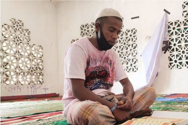 Muhammad Yusuf sedang membaca Quran di musala tempat penampungan di Lhokseumawe, Aceh.