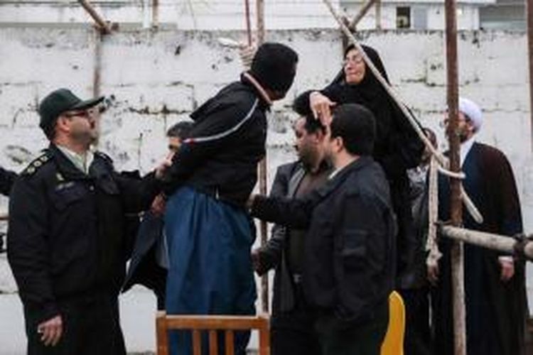 Ibu dari Abdolah Hosseinzadeh, menampar Balal yang membunuh putranya, saat proses hukuman gantung di Nowshahr, Iran, 15 April 2014. Ibu korban menampar lalu memaafkan Balal yang sudah berdiri di bawah tiang hukuman gantung dengan tali melingkari leher. Hukuman akhirnya dibatalkan secara dramatis.