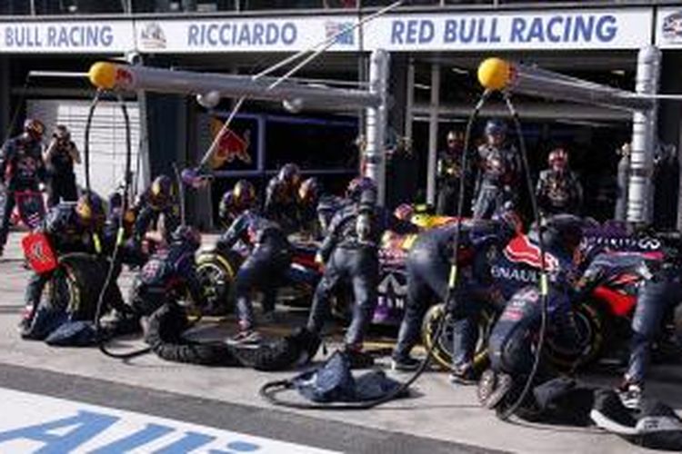 Tim Red Bull sedang memegang mobil Daniel Ricciardo yang melakukan pit stop pada GP Australia yang berlangsung di Sirkuit Albert Park, Melbourne, Minggu (16/3/2014).