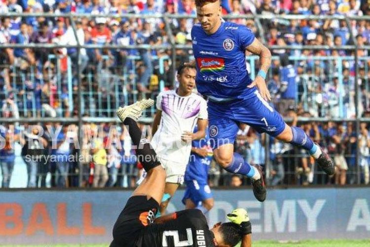 Striker Arema FC, Robert Lima Gladiator berebut bola dengan kiper Persita Tangerang, Yogi Triyana dalam leg pertama Babak 32 besar Piala Indonesia 2019 di Stadion Kanjuruhan Kepanjen, Kabupaten Malang, Sabtu (26/1/2019). 