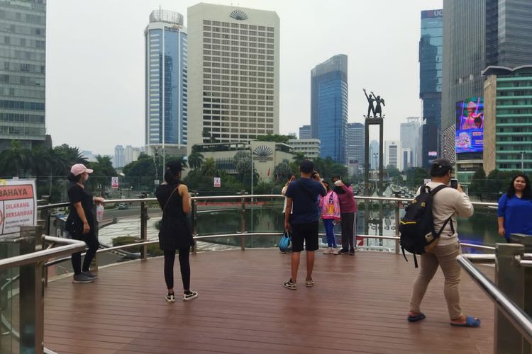 Warga mendatangi Halte Bundaran HI, Jakarta Pusat, untuk melakukan swafoto dengan latar belakang Monumen Selamat Datang, Minggu (9/10/2022).