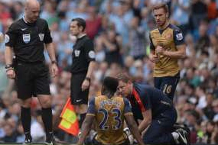 Striker Arsenal, Danny Welbeck (23), menjalani perawatan saat timnya melawan Manchester City pada partai Premier League di Stadion Etihad, Minggu (8/5/2016).