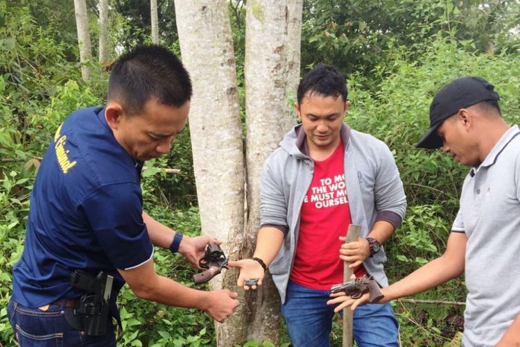 Kapolres Lhokseumawe AKBP Hendri Budiman (kiri) bersama perwira Polres Lhokseumawe menemukan dua senjata api jenis revolver setelah menggali tanah di  Desa Teupen Reusep Kecamatan Sawang, Kabupaten Aceh Utara, Minggu (5/11/2017).