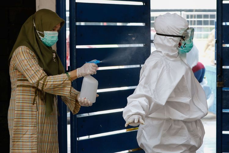 Petugas medis Dinas Kesehatan Kota Bogor disemprot disinfektan usai melakukan uji cepat (rapid test) massal Covid-19 dengan skema drive thru di GOR Pajajaran, Bogor, Sabtu (4/4/2020). Sebanyak 128 orang dalam pemantauan (ODP) mengikuti rapid test ini dari target 284 orang.