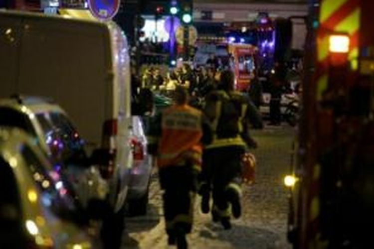 Tim medis Perancis bergegas mengevakuasi warga dari sebuah restoran yang berada tak jauh dari lokasi penembakan, Jumat (13/11/2015).