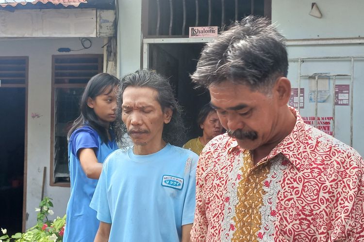 Henderson Harianja (49) (kiri) dan didampingi Ketua RT Anggiat Situmorang berjalan keluar dari kediamannya menuju mobil Kemensos sebelum berangkat ke RSJ di Jalan Pisang, Gang Delima RT/03/RW 09, Kelurahan Pardamean, Kecamatan Siantar Marihat, Kota Pematangsiantar, Sumatera Utara, Selasa (5/11/2024).