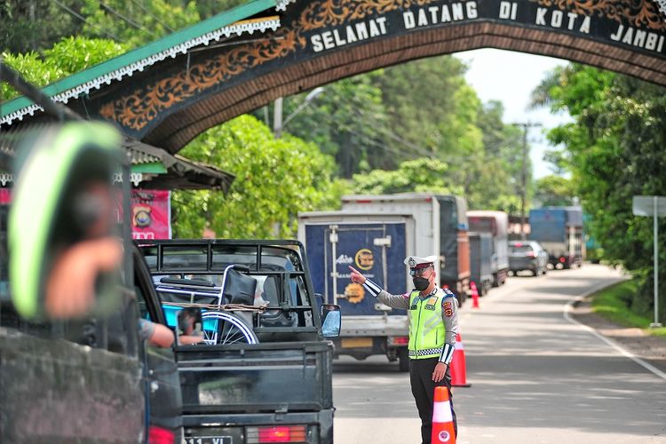 Petugas kepolisian mengarahkan pengemudi untuk berbelok menuju pos penyekatan di pintu masuk Kota Jambi, Jalan Lintas Sumatera, Kota Baru, Jambi, Senin (23/8/2021). Pemerintah Kota Jambi melakukan pengetatan Pemberlakuan Pembatasan Kegiatan Masyarakat (PPKM) level 4 mulai 23-29 Agustus 2021 dengan mendirikan pos penyekatan di 24 titik pintu masuk menuju kota itu dan memberlakukan sejumlah syarat perjalanan domestik di antaranya kartu vaksin dan hasil negatif tes cepat antigen COVID-19. ANTARA FOTO/Wahdi Septiawan/wsj.