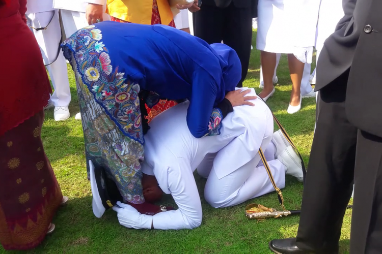 Letnan Dua TNI AL Tri Prasetyo bersujud di kaki sang ibu usai dilantik Presiden Joko Widodo sebagai perwira remaja di Istana Presiden, Selasa (25/7/2017).