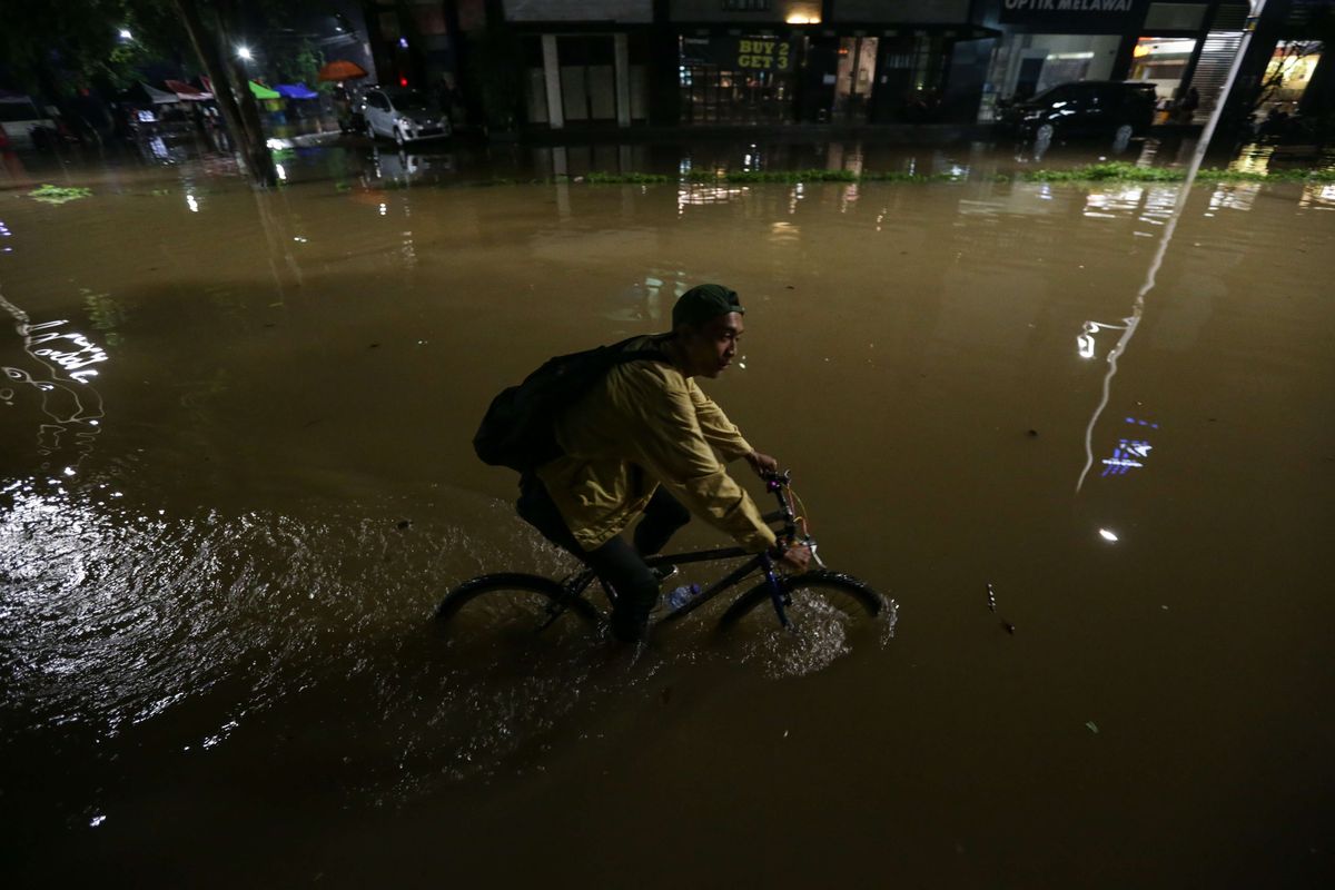 Warga melintasi banjir yang mengenang kawasan Kemang, Jakarta Selatan, Kamis (6/10/2022) malam. Hujan deras yang mengguyur wilayah Jakarta siang menyebabkan Jalan Kemang Raya, Jakarta Selatan, terendam banjir.