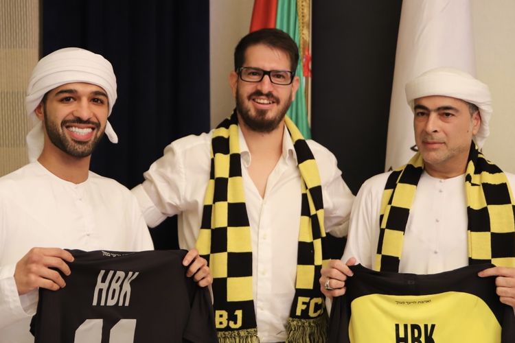 Sheikh Abu Dhabi Hamad bin Khalifa Al Nahyan (kanan) berpose bersama pemilik klub Liga Israel Beitar Jerusalem, Moshe Hovav (tengah). Pembelian klub Beitar oleh Sheikh Hamad menuai sorotan, karena klub itu dikenal menggaungkan rasialisme anti-Arab.