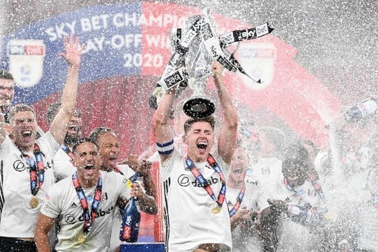 Tom Cairney mengangkat trofi setelah Fulham memastikan diri promosi ke Premier League 2020-2021. 