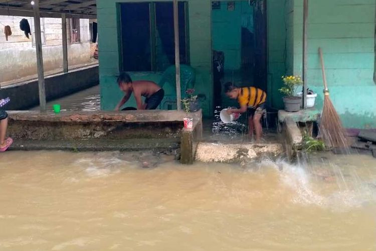 Warga di Desa Sei Bamban, Kecamatan Batang Serangan, Langkat membersihkan rumahnya setelah terrendam luapan Sungai Tenang dan Sungai Batang Serangan pada Minggu (22/11/2020) dini hari.