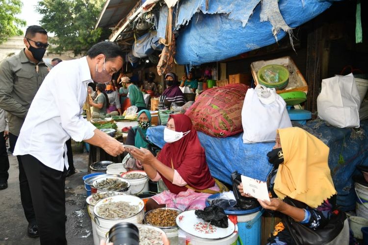 Presiden Joko Widodo saat menyerahkan sejumlah bantuan sosial (bansos) untuk pedagang di Pasar Kanoman, Kota Cirebon, Rabu (13/4/2022).