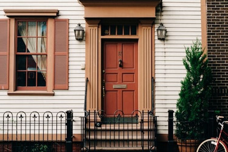 Ilustrasi pintu depan rumah berwarna coklat.