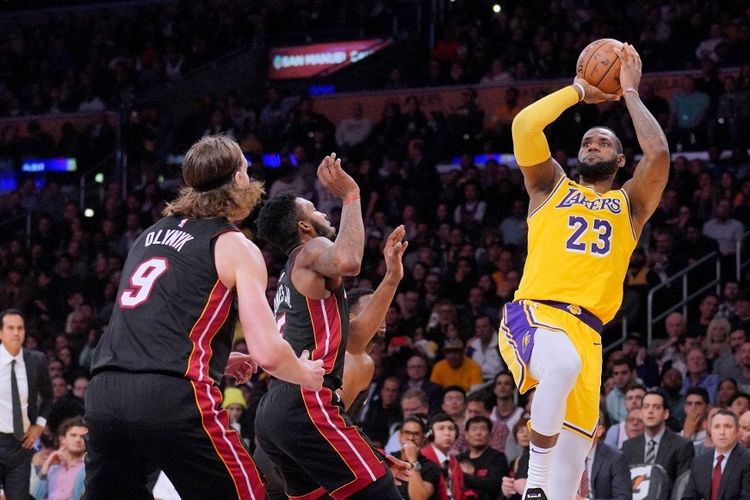 LeBron James dari Los Angeles Lakers mencoba melakukan fade away jumper di depan Derrick Jones Jr. dan Kelly Olynyk dari Miami Heat saat Lakesr menang 108-105 di Staples Center pada 10 Desember 2018 di Los Angeles, California.