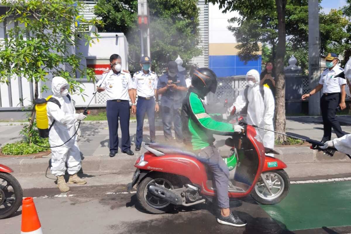 Penyemprotan Ojol dengan disinfektan di depan kantor Dishub Jatim Jalan Ahmad Yani Surabaya, Minggu (22/3/2020).