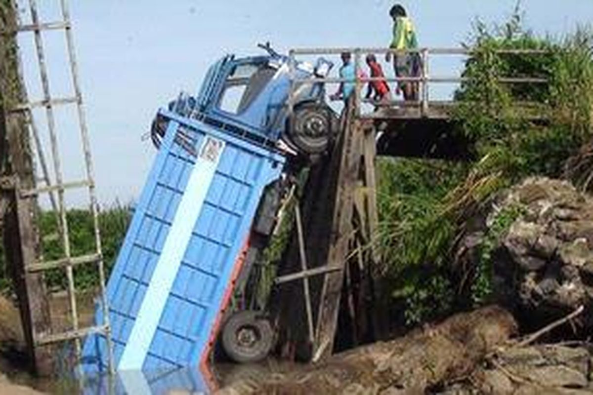 Satu truk terperosok saat melewati sebuah jembatan yang runtuh di Kecamatan Pitu Riase, Kabupaten Sidrap, Sulawesi Selatan, Selasa (4/12/2012). 