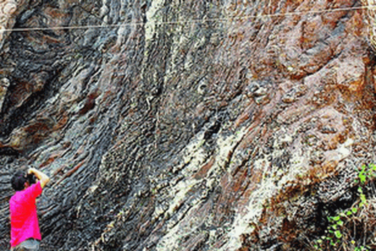 Andri (30), wisatawan asal Banjarnegara, Jawa Tengah, mengabadikan salah satu singkapan geologi batuan metamorf di Kompleks Geowisata Karangsambung, Kabupaten Kebumen, Jateng, Kamis (11/10/2012). Cagar alam geologi seluas 22.000 hektar ini menyimpan kekayaan geologi terlengkap di Jawa.