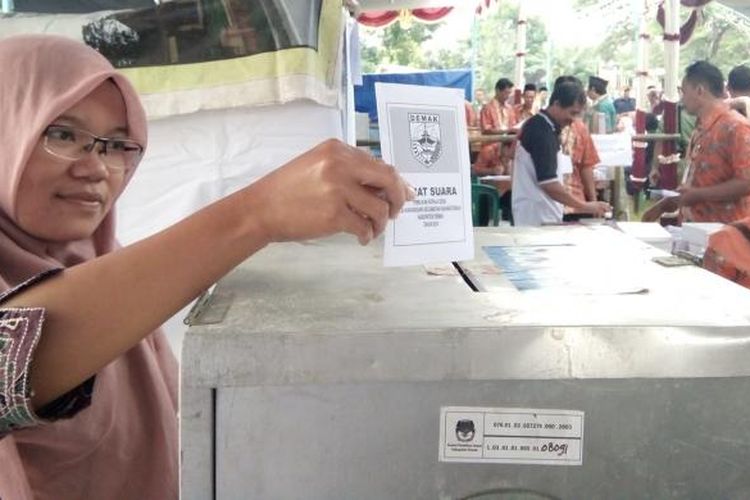 Kusfitria warga Desa Karangsari Kecamatan Karangtengah Demak memasukan surat suara dalam gelaran pilkades di desanya,  Minggu (9/10/2016)