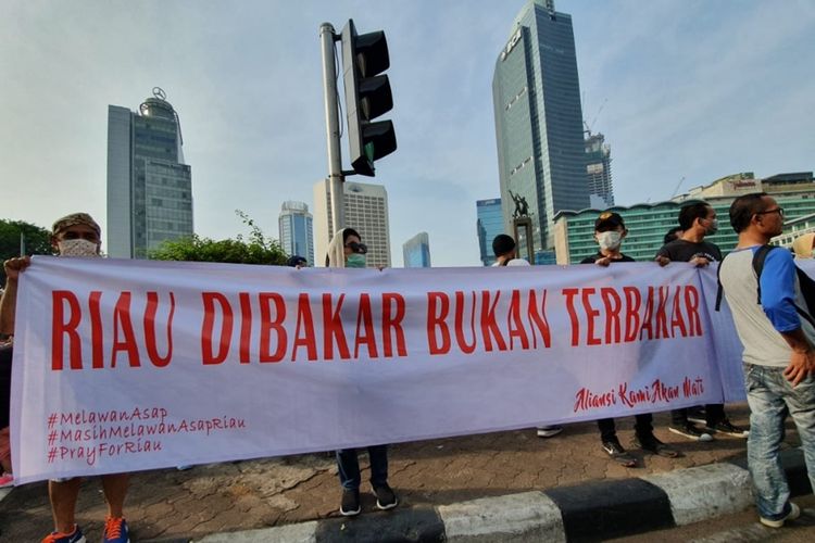 Warga Riau yang tergabung dalam Persatuan Masyarakat Riau Jakarta (PMRJ) gelar aksi pakai masker di Car Free Day (CFD), Jalan Jenderal Sudirman, Jakarta Pusat, sebagai bentuk kepedulian bencana kabut asap di Provinisi Riau, Minggu (15/9/2019).