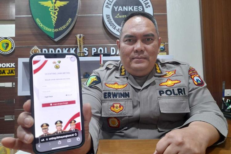 Kabid Dokkes Polda Jatim Kombes dr Erwin Zainul Hakim menunjukkan aplikasi Si Centing Jawi Wetan.