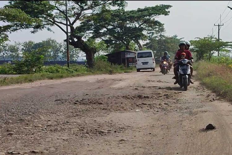 Sejumlah warga melintasi jalan rusak di kawasan Jalan Raya Nyimas Cangkring, Kecamatan Plered, Kabupaten Cirebon, Jawa Barat, Selasa (9/5/2023) pagi.