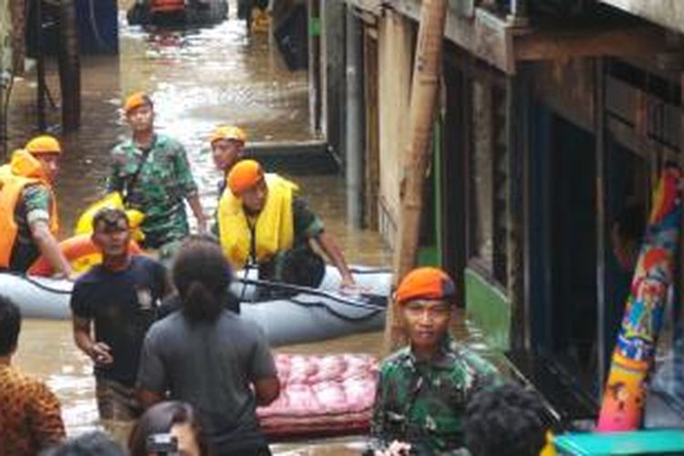 Korps Pasukan Khas TNI AU membantu evakuasi warga korban banjir di Kampung Pulo, Jakarta Timur. Selasa (14/1/2014).