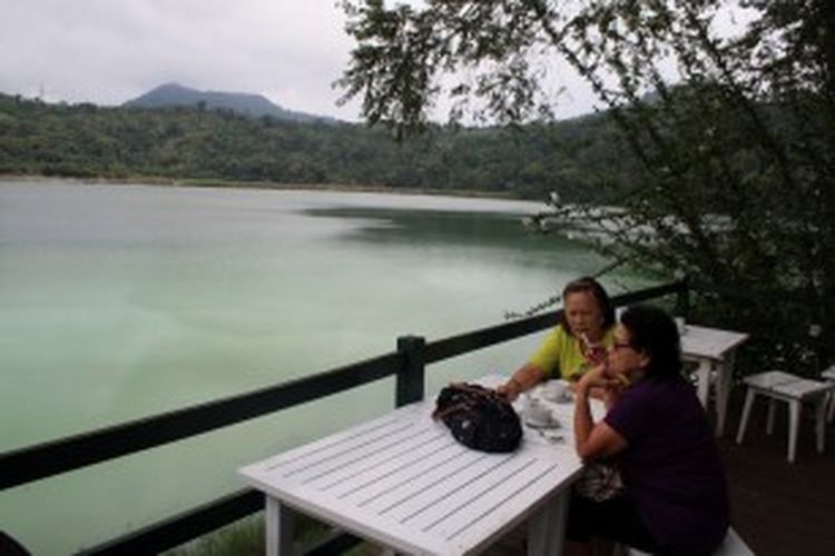 Pengunjung tengah bersantai di tepi Danau Linow, Sulawesi Utara.