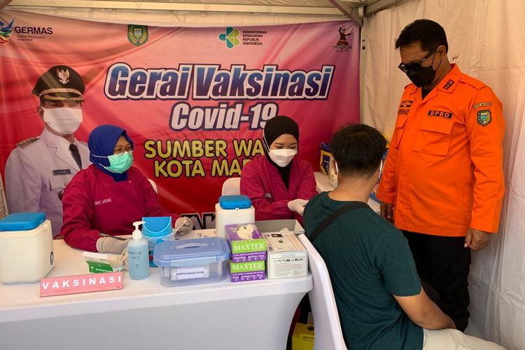 SUNTIK VAKSIN—Petugas menyuntik vaksin covid-19 kepada salah satu warga di pusat keramaian Sumber Wangi, di Jalan Pahlawan, Kota Madiun, Jawa Timur,.