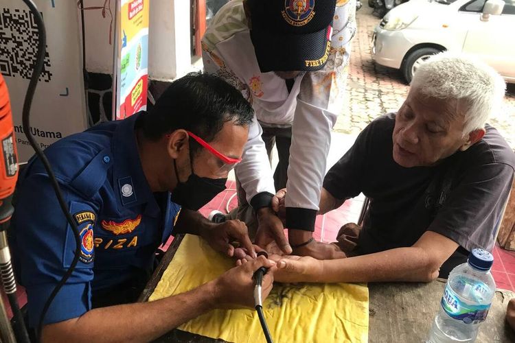 Petugas satpol PPK Trenggalek Jawa Timur, berupaya melepas cincin di jari warga dengan menggunakan peralatan khusus. Jumat (11/11/2022).
