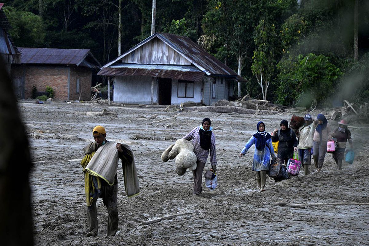 Warga mengangkat barang miliknya melewati material lumpur di Desa Radda, Kabupaten Luwu Utara, Sulawesi Selatan, Sabtu (18/7/2020). Pascabanjir bandang sejumlah warga yang terdampak mulai mengambil barangnya yang masih bisa digunakan.