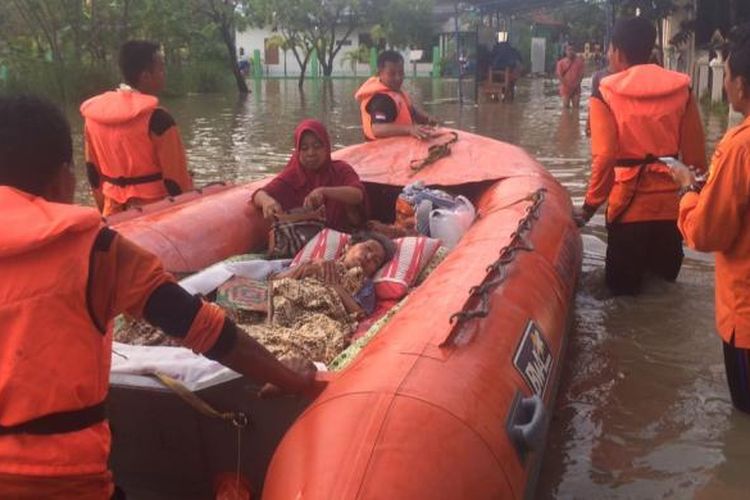 Anggota Basarnas Pos SAR Cilacap dan Jawa Tengah mengevakuasi seorang nenek korban banjir di Kota Baru, Brebes, Jumat (17/2/2017).