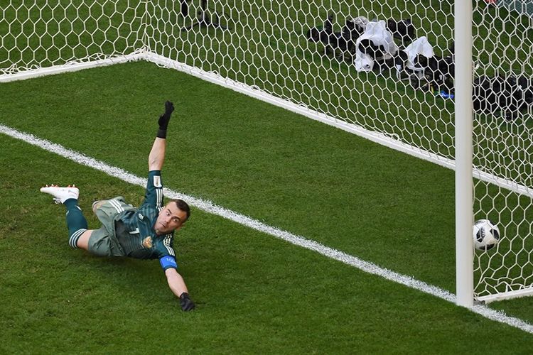 Penjaga gawang Rusia, Igor Akinfeev (kiri), gagal menjangkau bola tendangan bebas Luis Suarez yang berbuah gol pertama dalam laga penyisihan Grup A Piala Dunia 2018 di Samara Arena, Samara, Senin (25/6/2018).