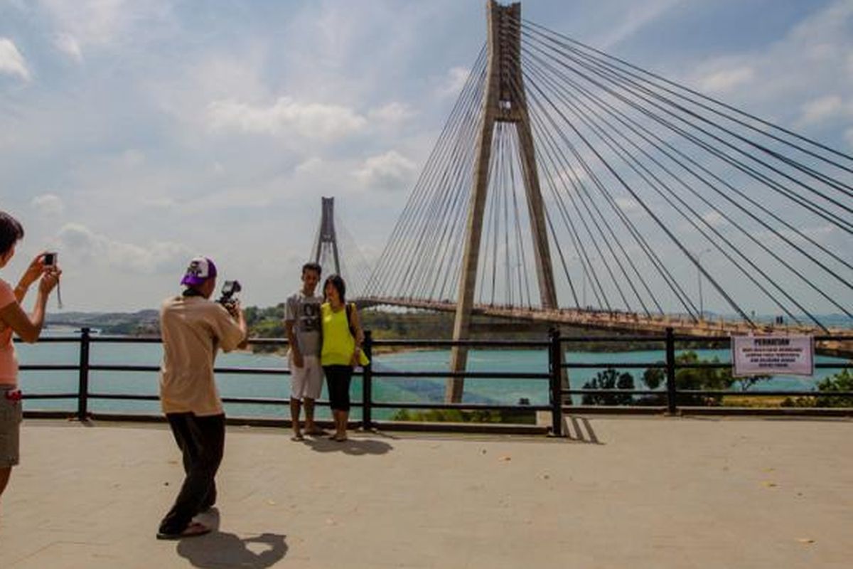 Warga berfoto dengan latar belakang pemandangan Jembatan Barelang di Batam, Kepulauan Riau, Minggu (8/2/2015). Jembatan ini merupakan satu dari enam jembatan yang dibangun untuk menghubungkan enam pulau di Batam, yaitu Pulau Batam, Pulau Tonton, Pulau Nipah, Pulau Rempang, Pulau Galang dan Pulau Galang Baru.