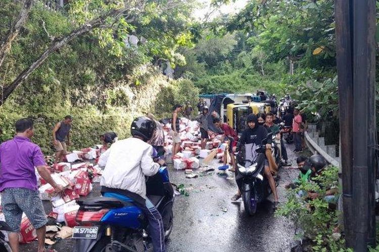 Berserakan - Puluhan kardus Bir Singaraja berserakan di Jalan Goa Gong Jimbaran, Kecamatan Kuta Selatan, Badung, pada Minggu 29 Januari 2023 setelah truk yang mengangkut terguling - Truk Pengangkut Terguling di Tanjakan Goa Gong Jimbaran Bali, Puluhan Kardus Bir Berserakan di Jalan 
