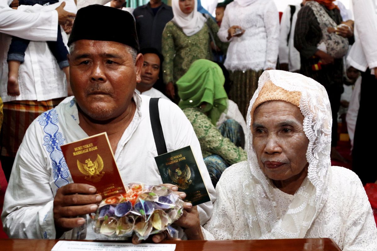 Pasangan pengantin Mang Kus dan Marsiati mengikuti nikah massal yang diselenggarakan Partai Kebangkitan Bangsa di KUA Menteng, Jakarta Pusat, Jumat (25/8/2017). Sebanyak 103 pasangan pengantin mengikuti acara ini.