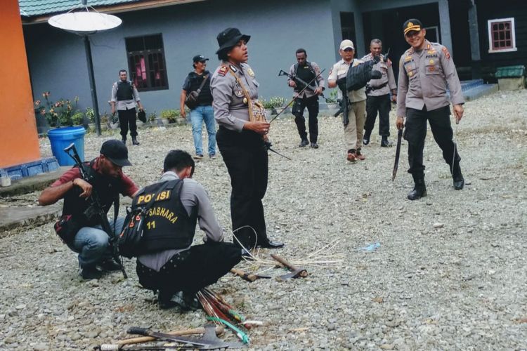 Polisi saat mengumpulkan alat perang hasil razia.