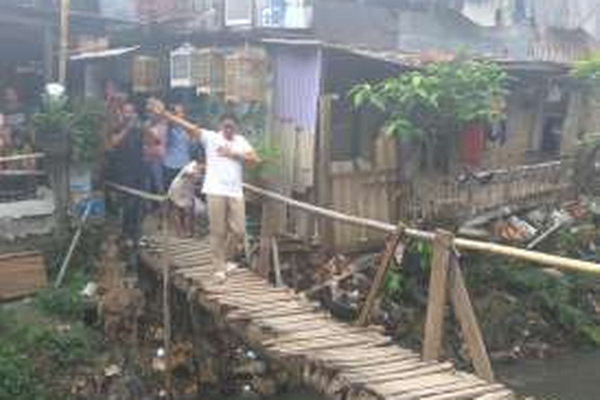 Calon wakil gubernur DKI Jakarta Sandiaga Uno melintasi jembatan di RT 02 RW 05, Halim, Makassar, Jakarta Timur, Kamis (8/12/2016).