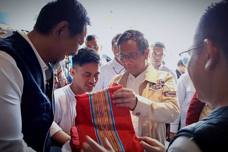 Calon wakil presiden (Capres) nomor urut 3 Mahfud MD yang tiba dan langsung dipasangi sarung tenun khas Toraja oleh relawannya di salah satu kafe di Jalan Perintis Kemerdekaan, Kota Makassar, Sulsel, Sabtu (13/1/2024).