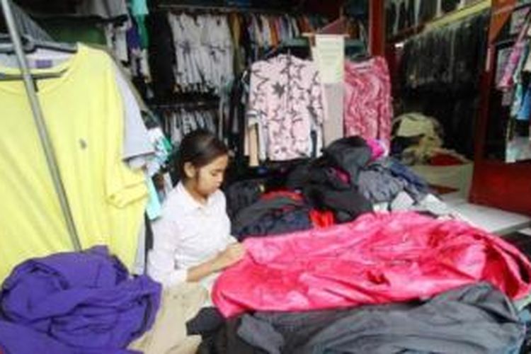 Penjual memilah pakaian merek-merek tertentu yang unik dan berkualitas di Toko Barang Bekas Bos (Babebo) di Kawasan Mergosono, Kota Malang, Senin (25/11/2014). 

