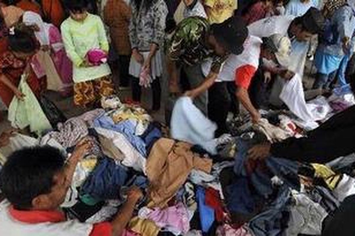 Pengungsi korban Merapi berebut mendapatkan pakaian bekas layak pakai sumbangan dermawan di barak pengungsian GOR Gelarsena, Klaten, Jawa Tengah, Minggu (7/11/2010). Sumbangan pakaian layak pakai sangat diperlukan karena sebagian pengungsi telah kehabisan pakaian sebab saat mengungsi mereka belum sempat membawa pakaian.
