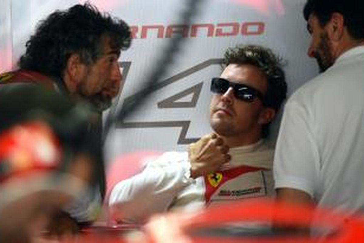 Pebalap Ferrari asal Spanyol, Fernando Alonso, berada di pit Sirkuit Hockenheim pada sesi latihan pertama GP Jerman, Jumat (18/7/2014).