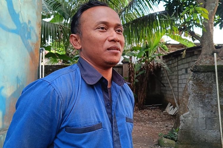 Warga Banjar Giri Dharma, Wayan Sumada di depan tembok belakang rumah yang dia bongkar untuk jalan keluar sebelum tembok pembatas dibongkar GWK, pada Rabu (1/10/2025). 
