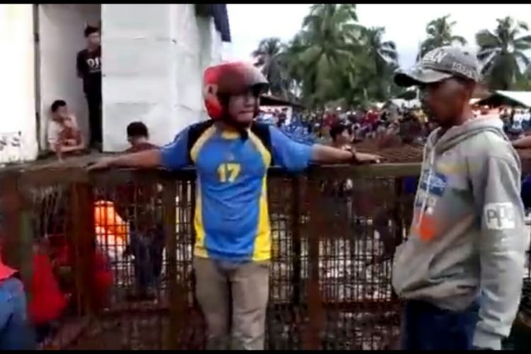 Warga membantu petugas saat memasang perangkap harimau sumatera di lorong ruko dikawasan pasar desa pulau burung