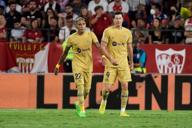 Reaksi Raphinha dan Robert Lewandowski setelah Barcelona mencetak gol ke gawang Sevilla di Stadion Ramon Sanchez-Pizjuan pada Minggu (4/9/2022) dini hari WIB.
