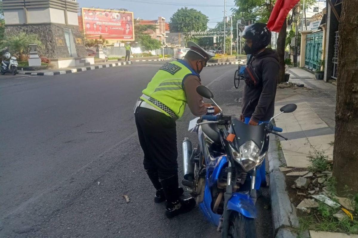 Sepeda motor yang menggunakan knalpot brong dilakukan penilangan oleh pihak kepolisian di Gresik, Rabu (13/4/2022).