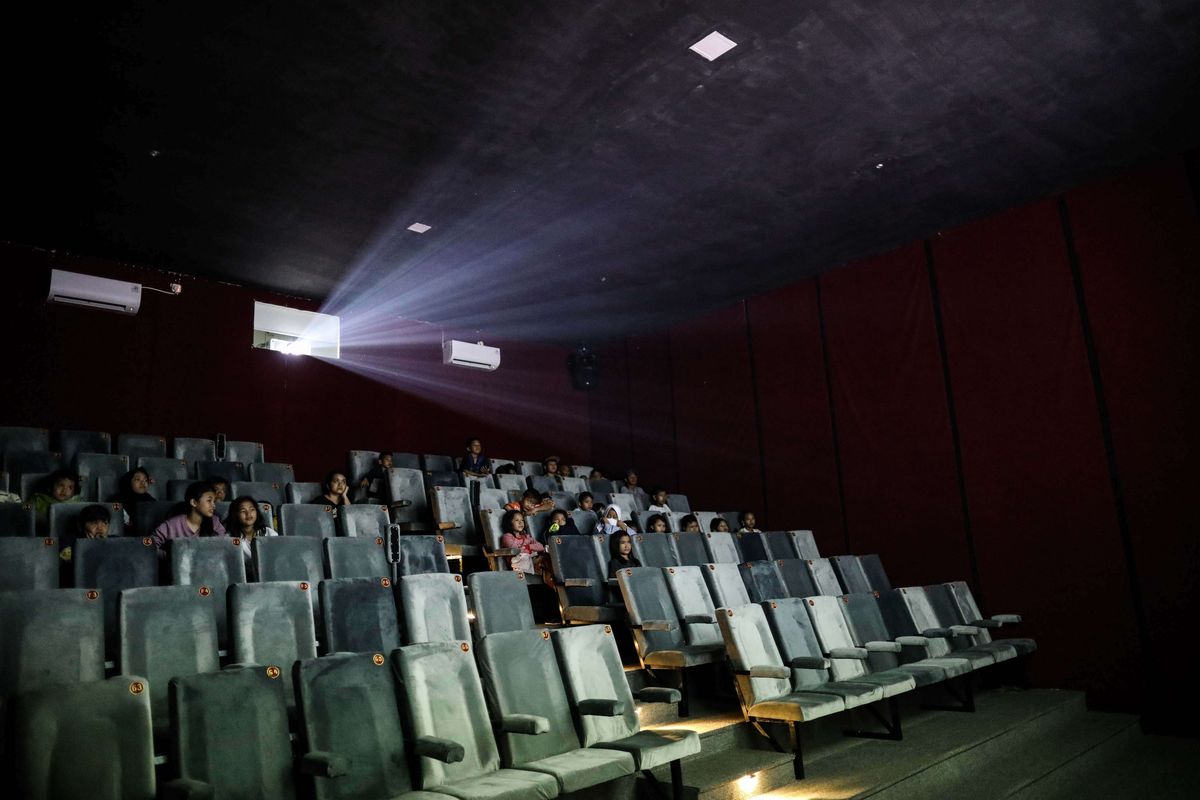 Warga menonton bioskop di Pasar Teluk Gong, Penjaringan, Jakarta Utara, Jumat (5/7/2019). Perumda Pasar Jaya bekerja sama dengan Persatuan Artis Film Indonesia membangun bioskop rakyat bernama Indiskop atau Bioskop Independen dengan fasilitas dua studio yang berkapasitas masing-masing 128 kursi penonton untuk masyarakat berpenghasilan menengah ke bawah untuk ruang belajar produksi film serta mengajak masyarakat agar gemar menonton film Indonesia.