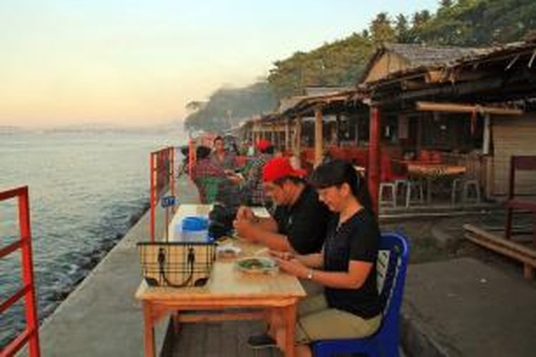 Pengunjung sedang menikmati kuliner di Sabua Bulu yang terdapat di sepanjang Pantai Malalayang Manado.